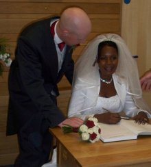 Ian and Anette Ringland sign the register after their wedding in Holy Trinity Woodburn.